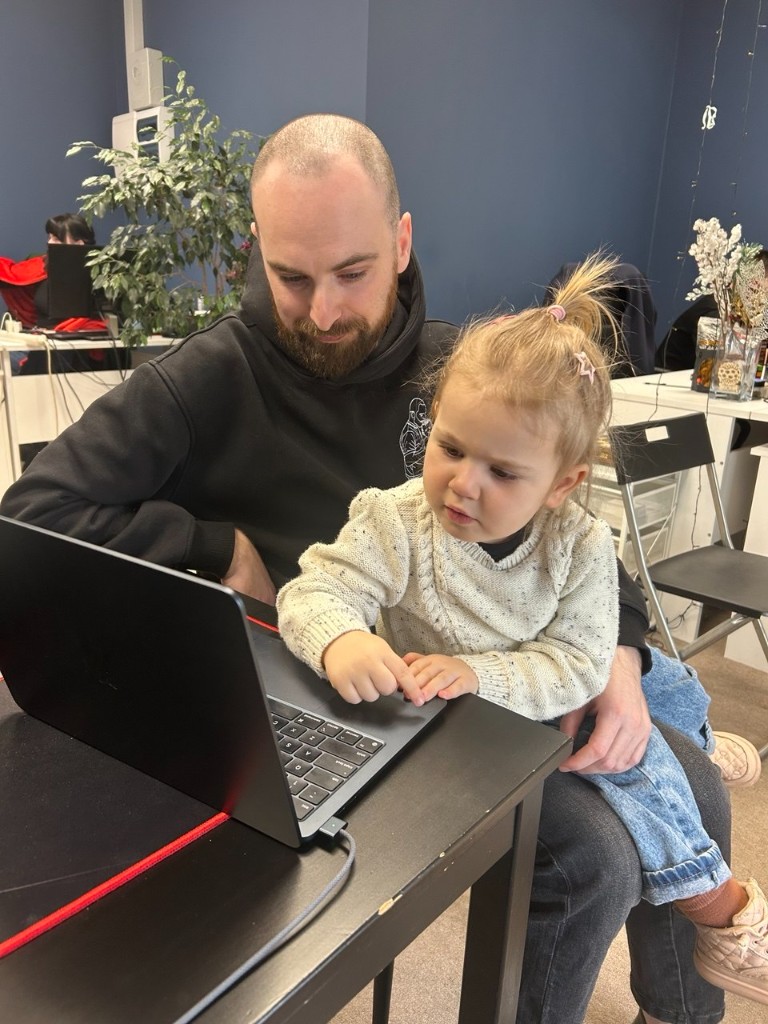 Working with my little helper — Sometimes the best SEO ideas come not from staring at monitors, but from the one tugging at your sleeve to show you how to press buttons on a MacBook